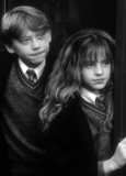 Ron, Harry und Hermine tragen Umhänge. Bild in schwarzweiß.