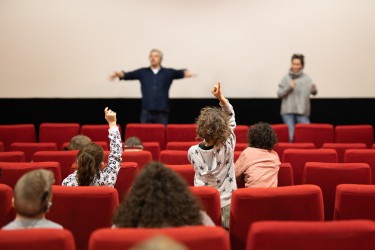 Ein Kinosaal. Auf der Leinwand ein Animationsfilm mit kleinen Monstern.