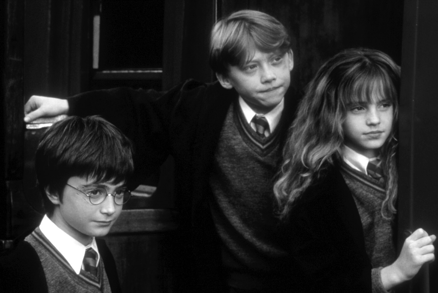 Ron, Harry und Hermine tragen Umhänge. Bild in schwarzweiß. 